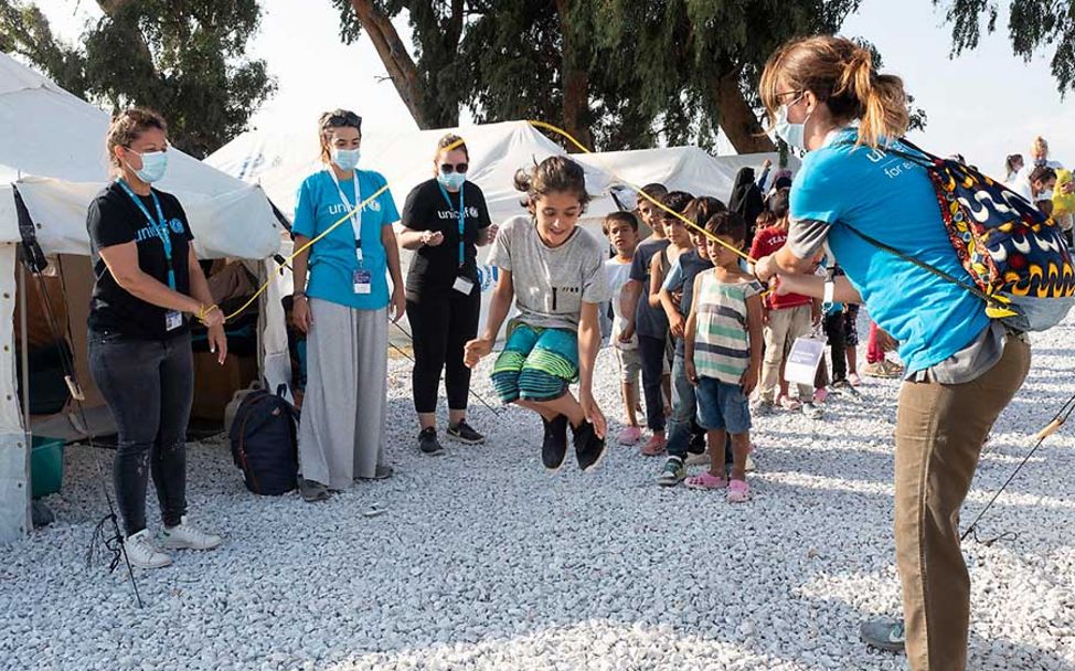 Lesbos: Kinder beim Seilchen springen mit UNICEF-Helfern