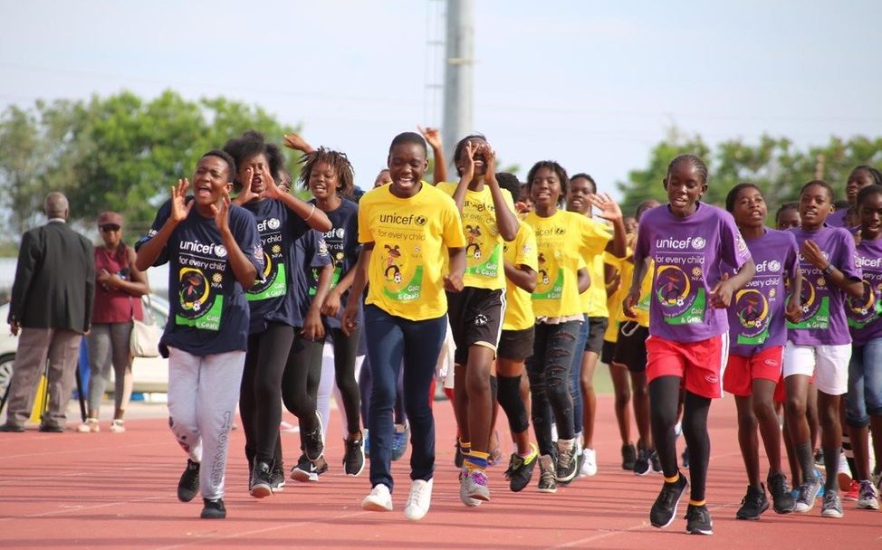 Sporttraining: Mädchen in Namibia joggen in mehreren Reihen hintereinander. 