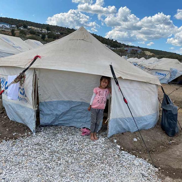 Ein Mädchen steht im Flüchtlingslager Kara Tepe barfuß vor ihrem Zelt. 