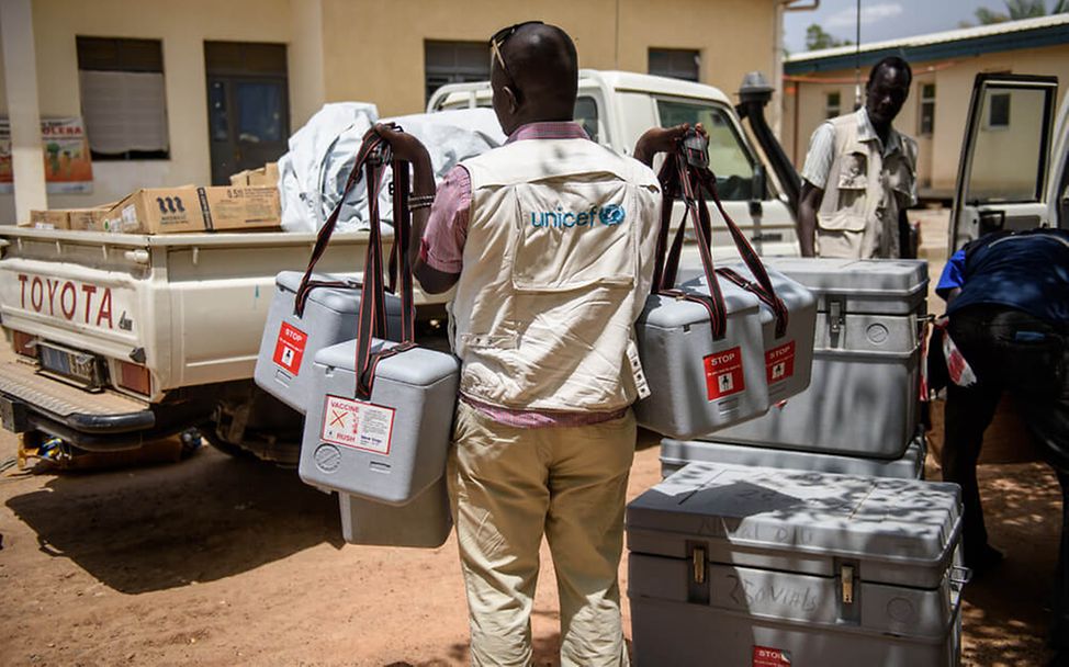 UNICEF: Im Südsudan trägt ein Helfer Kühlboxen mit Impfstoffen
