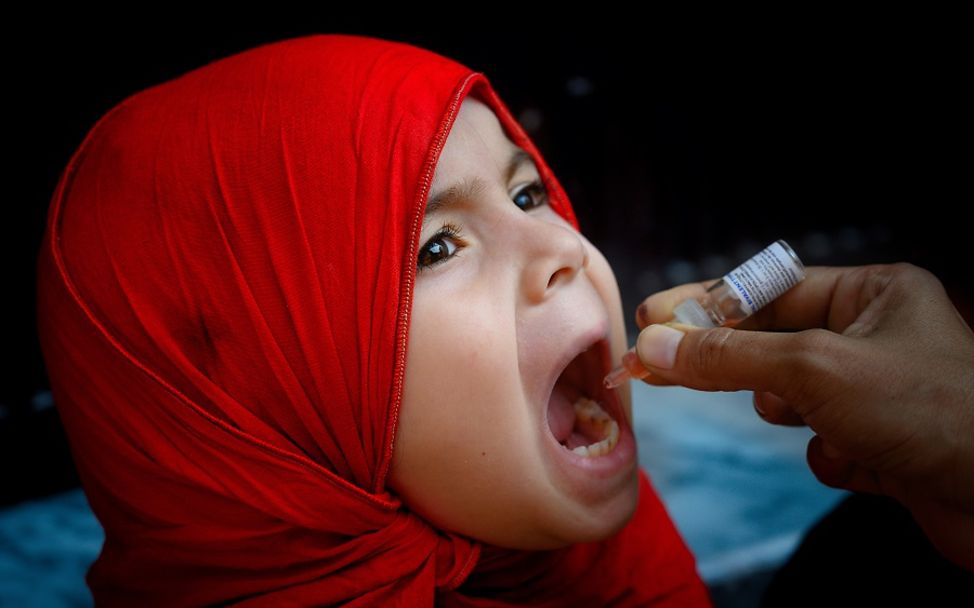 Polio: Mädchen aus Pakistan erhält eine Schluckimpfung