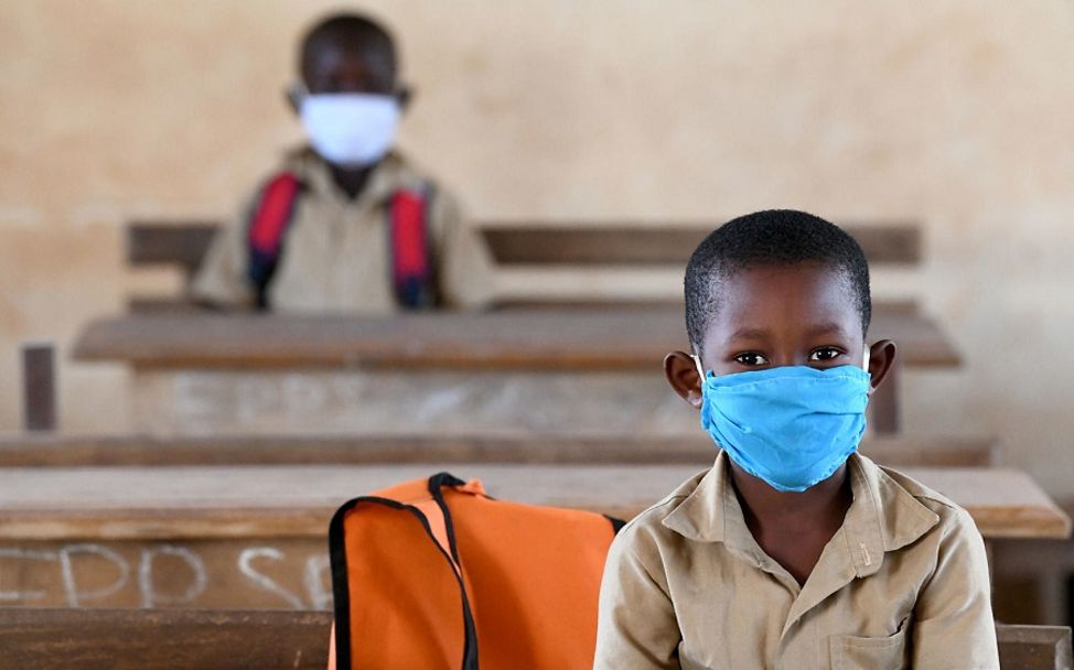 Elfenbeinküste: Zwei Schüler sitzen mit Maske in der Schulbank