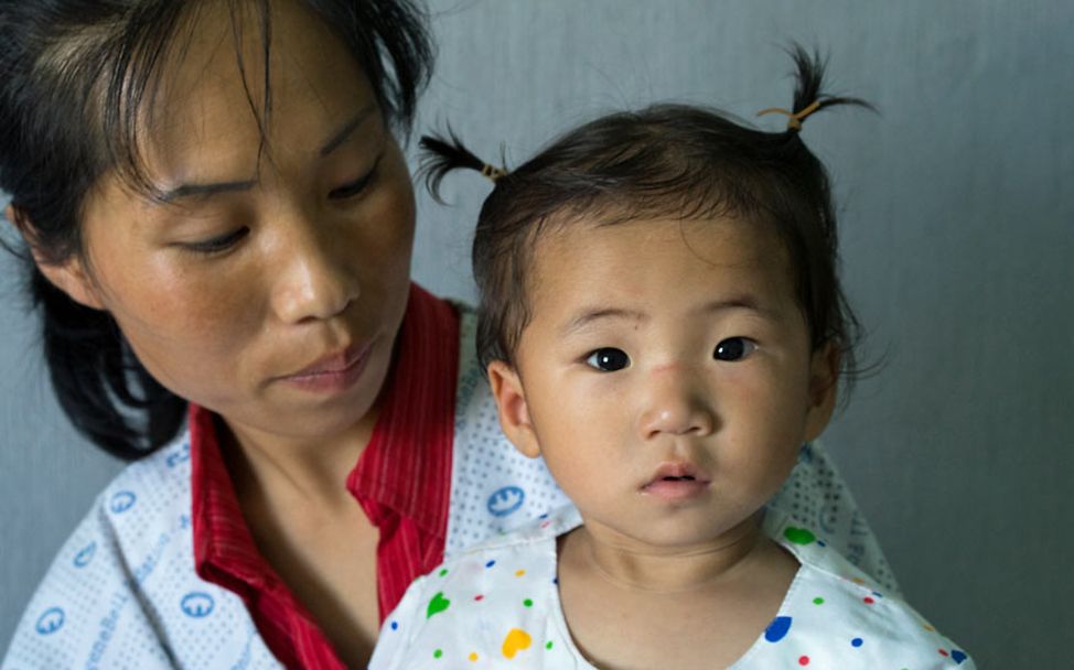 Hunger in Nordkorea: Eine Mutter hält ihre zweijährige Tochter auf dem Arm. 