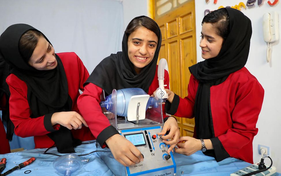 Afghanistan: Drei Mädchen zeigen ein selbstgebautes Beatmungsgerät.
