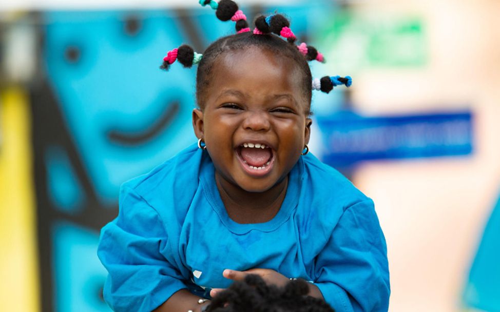 Elfenbeinküste: Ein Mädchen lacht aus vollem Hals