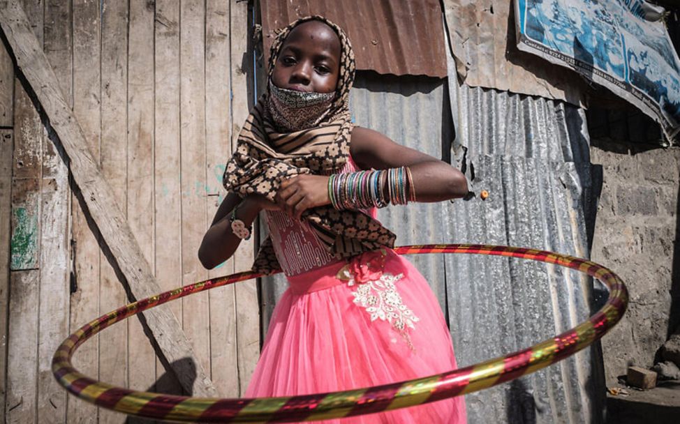 Kenia: Ein Mädchen spielt mit einem Hula Hoop Reifen