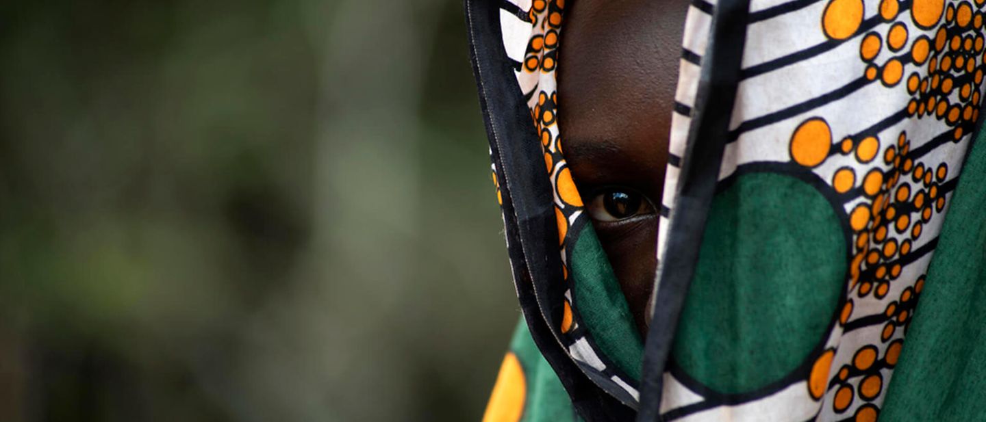 Mädchenbeschneidung in Uganda: Ein Mädchen schaut unter ihrem Kopftuch hervor
