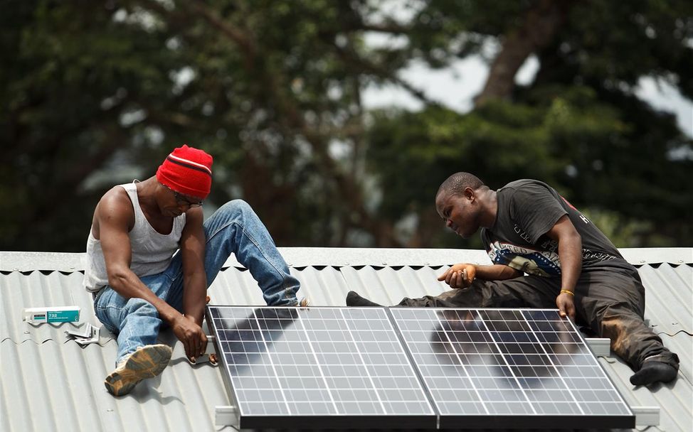 Sierra Leone: Techniker installieren Solarzellen.