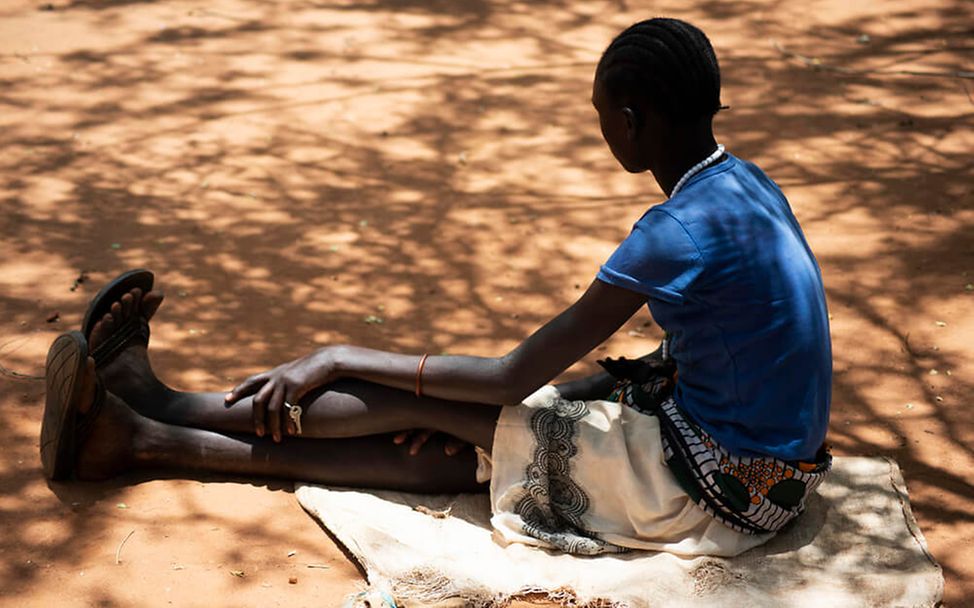 Mädchenbeschneidung in Uganda: Ein Mädchen sitzt auf dem Boden