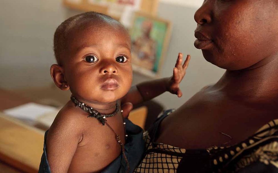 Burkina Faso: Eine Mutter hält ihre unterernährte Tochter auf dem Arm © UNICEF/Asselin