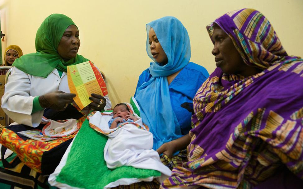 FGM im Sudan: Eine Freiwillige klärt eine junge Mutter über Mädchenbeschneidung auf