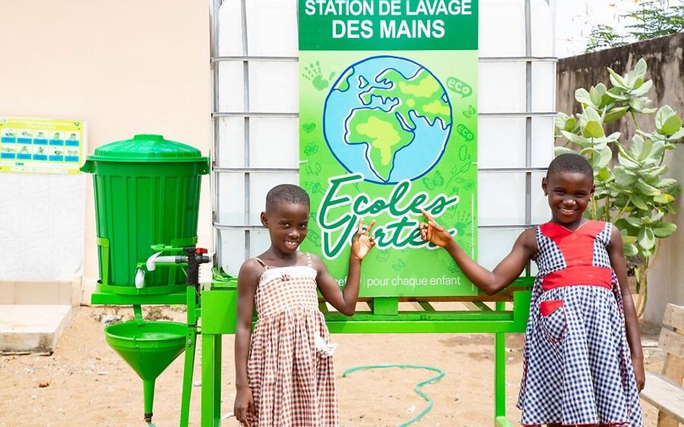 Zwei Mädchen präsentieren stolz ihre neue Hygienestation.