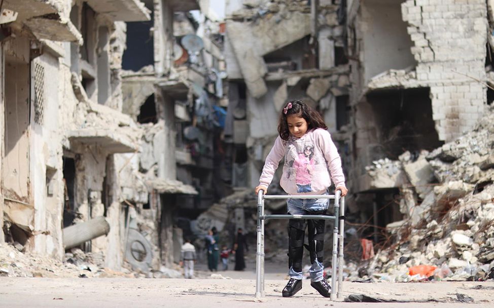 Syrien: Rama läuft mit ihrer Gehhilfe durch Trümmer in Aleppo.