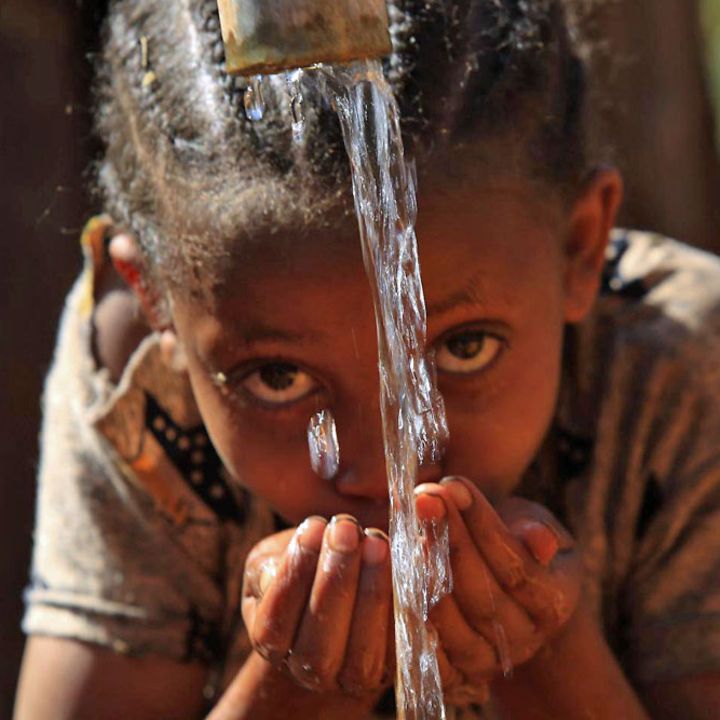 Wassermangel in Äthiopien: Ein Mädchen trinkt an einer Wasserstelle frisches Wasser aus ihren Händen.
