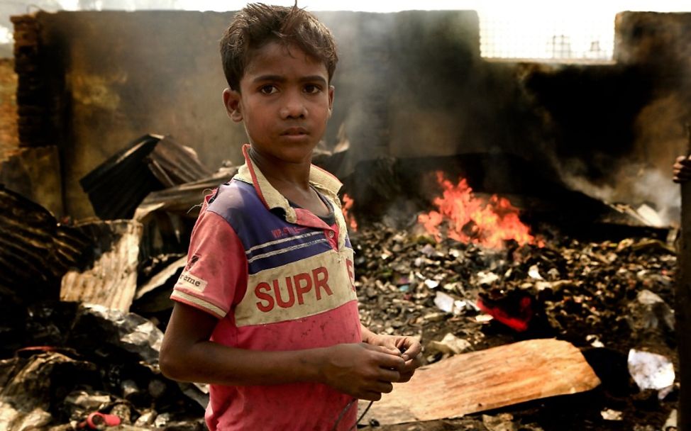 Bangladesch 2021: Junge steht vor den Trümmern des brennenden Camps der Rohingya.