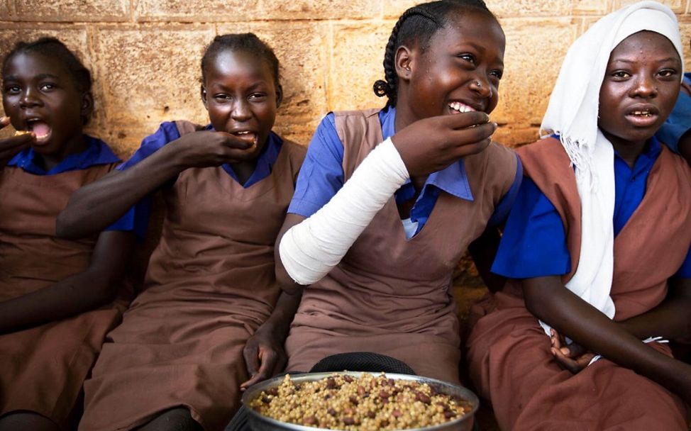 Südsudan 2019: Lachend genießen die Mädchen ihr warmes Mittagessen in der Schule. 