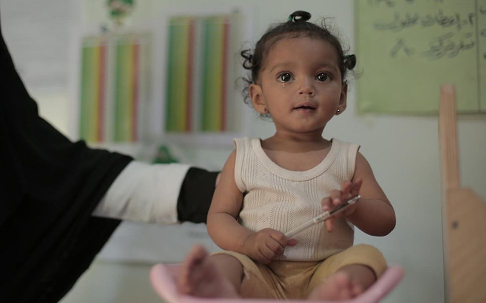 Jemen spenden: Ein Baby sitzt in einem Krankenhaus auf einer Waage. 