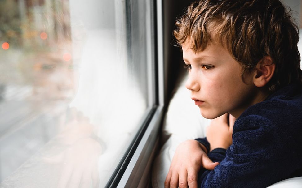 Kinder in Deutschland: Junge schaut aus dem Fenster