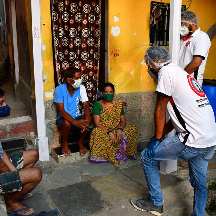 Corona in Indien: Helfer erklären einer Familie, wie sie sich schützen kann