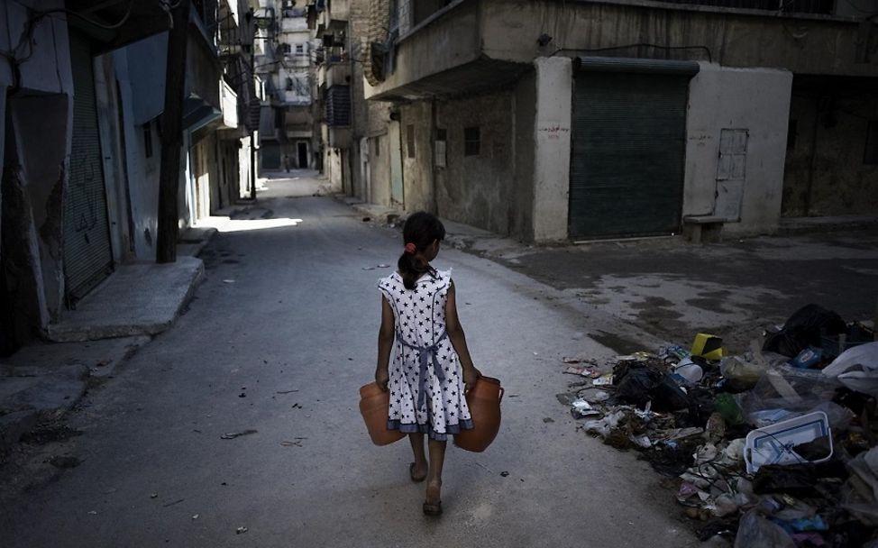 Syrien: Ein Mädchen trägt einen Kanister mit Wasser durch die Straßen von Aleppo.