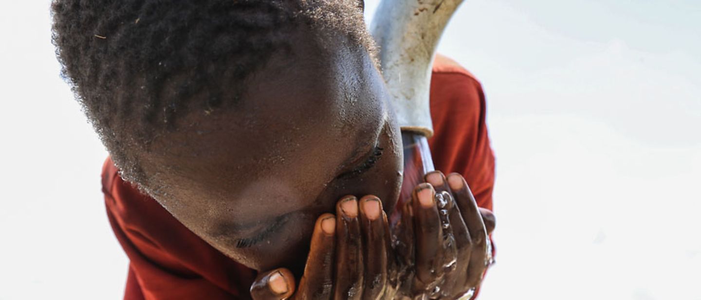 Weltwassertag 2018: Ein Junge trinkt aus einem Wasserhahn. 
