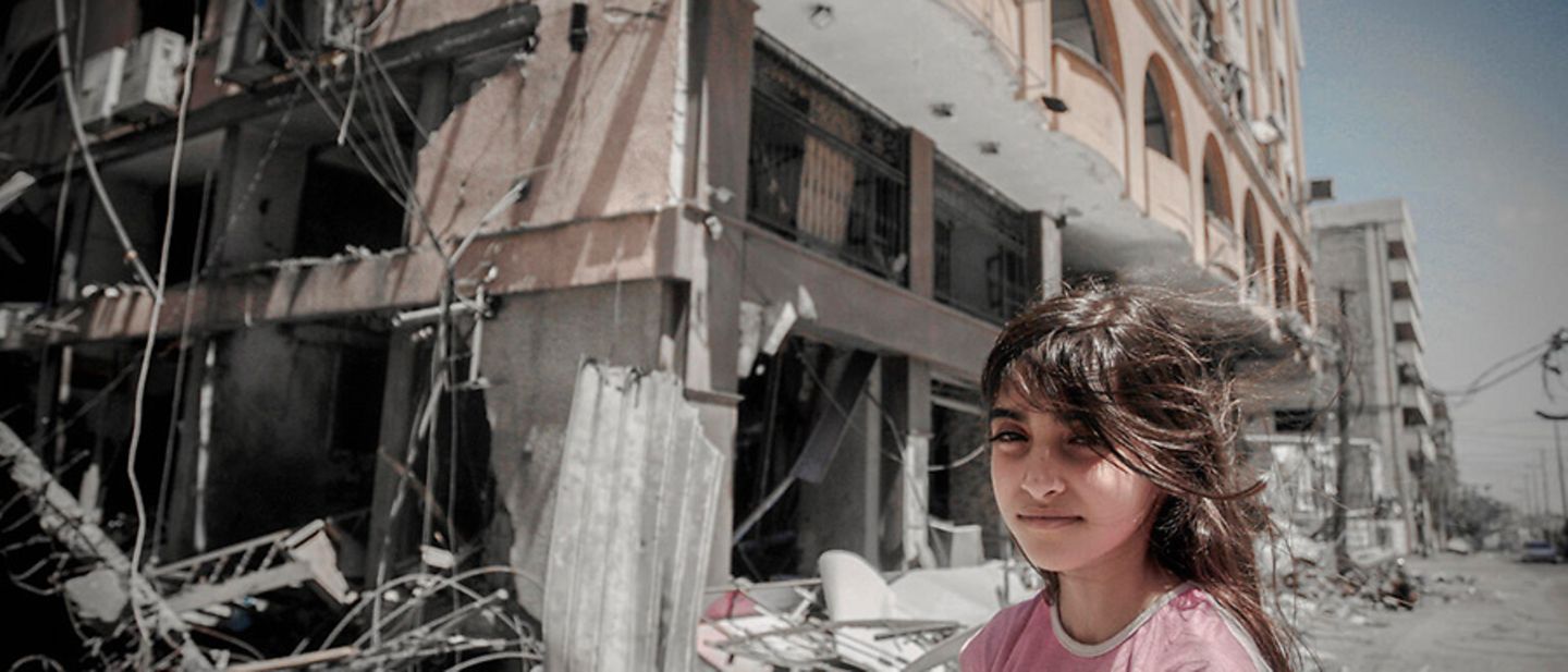 Palästina: Ein Mädchen steht vor einem zerstörten Gebäude.