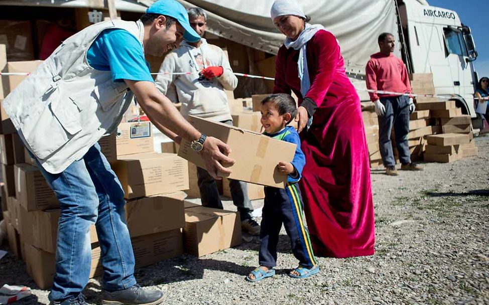 Nothilfe in Krisen: UNICEF-Helfer verteilen Hilfspakete an Flüchtlinge im Irak.