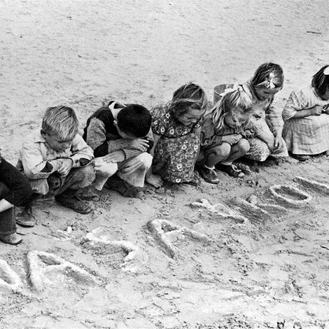 75 Jahre UNICEF: Jugoslawische geflüchtete Kinder schreiben in den Sand in Ägypten
