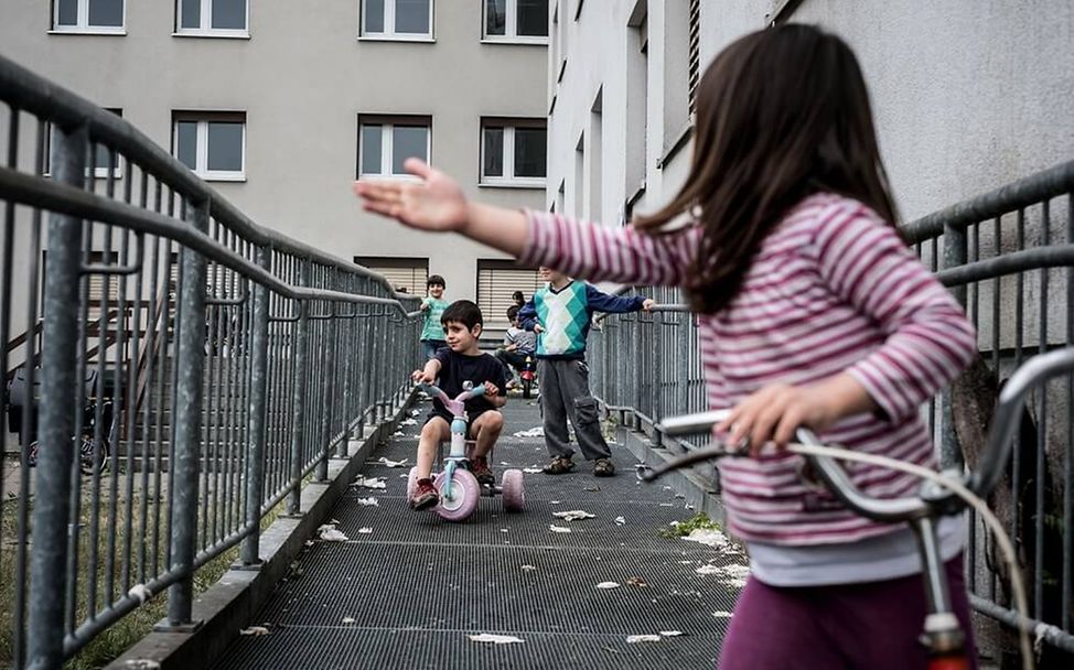 Flüchtlingsheim: Kinder spielen mit Dreirädern.