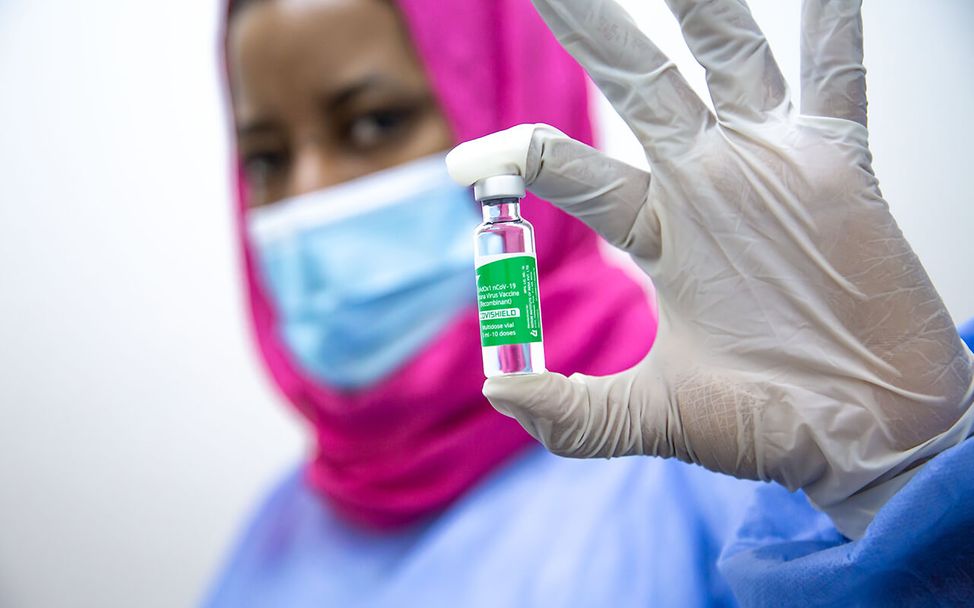 Eine Krankenpflegerin zeigt den Corona-Impfstoff.