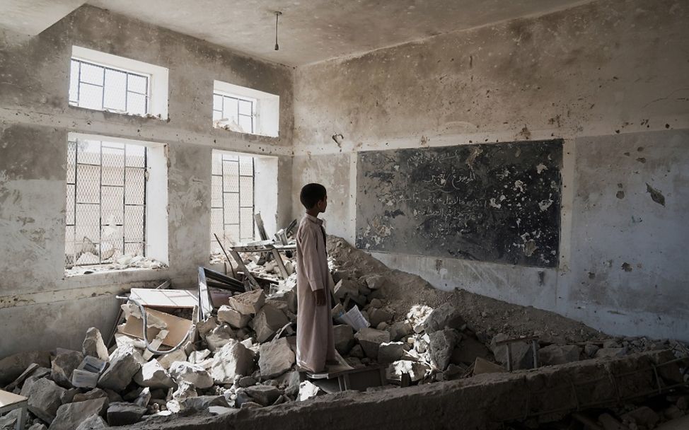Jemen: Kind steht inmitten eines zerstörten Klassenzimmers.
