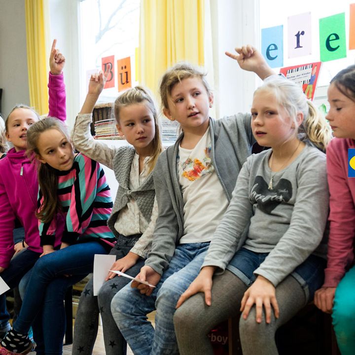 IKEA Kinderrechte: Schülerinnen zeigen auf, um sich zu beteiligen.