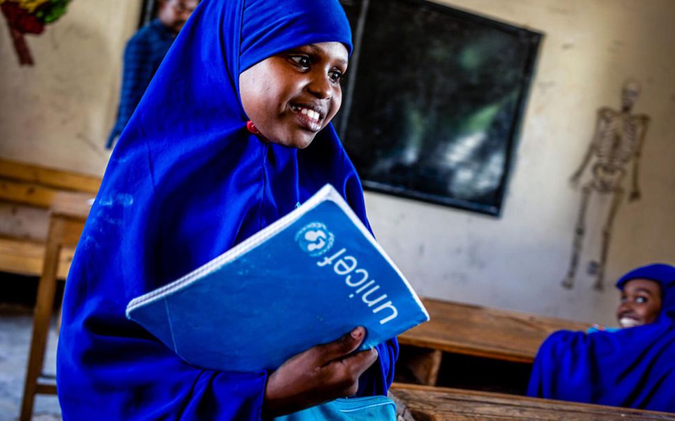 Bildung in Somalia: Das Mädchen Halimo mit einem Schulheft von UNICEF