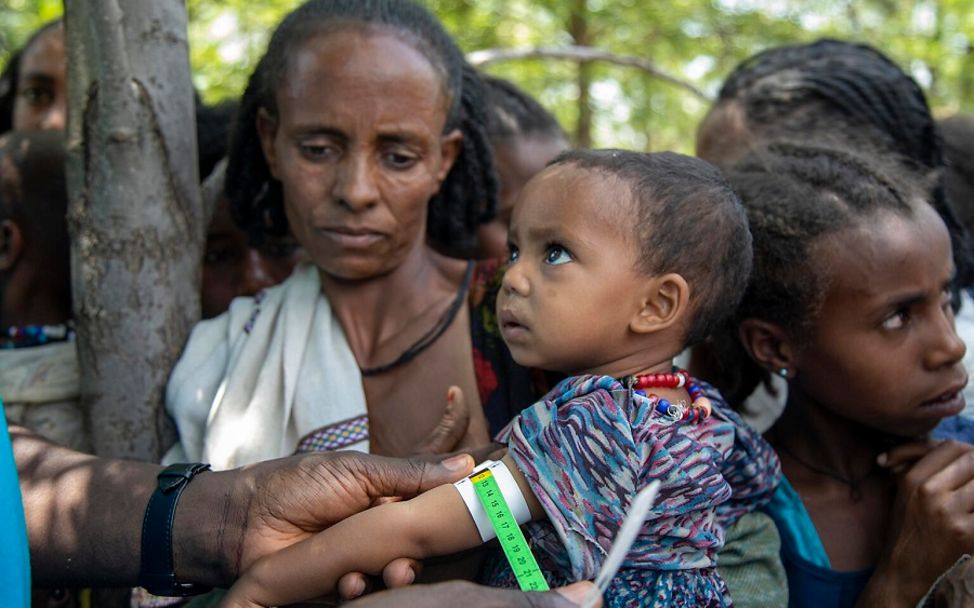 Ein Gesundheitshelfer misst den Armumfang des kleinen Jungen in Äthiopien.