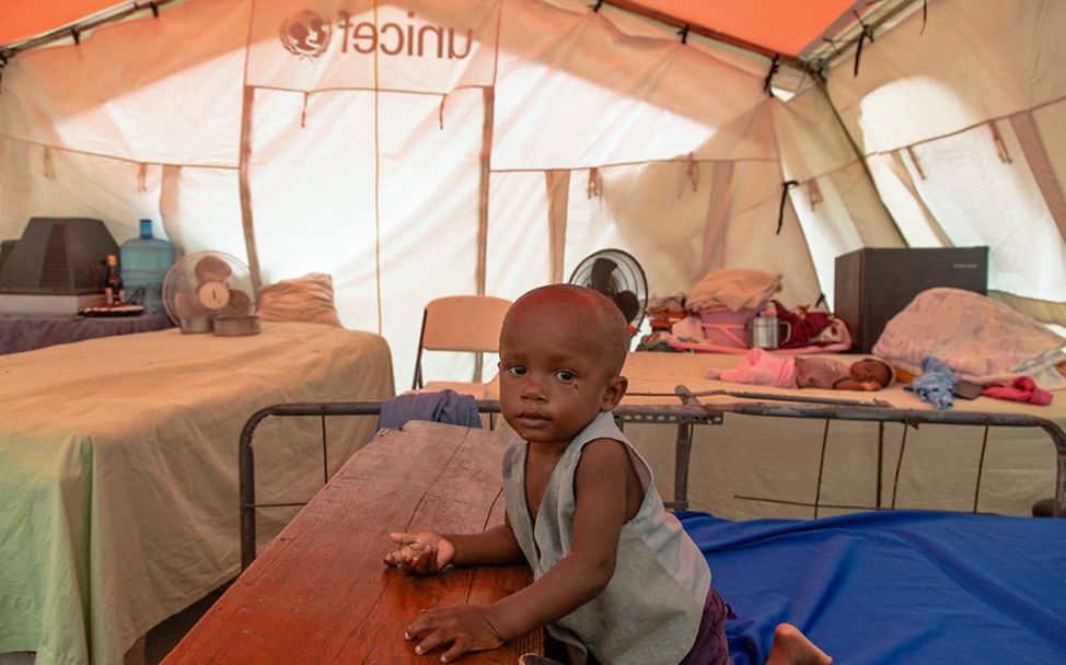 Erdbeben Haiti Nothilfe: Ein Kleinkind sitzt nach dem Erdbeben-Unglück auf einem Bett in einem UNICEF-Notzelt. 