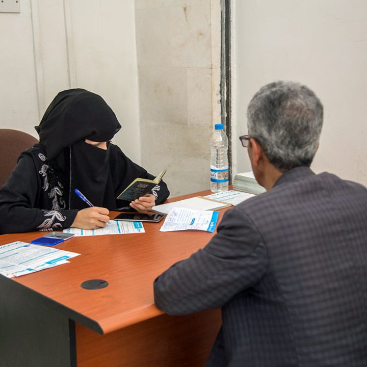 Bargeldhilfe (cash transfer) im Jemen: Eine Bankangestellte zahlt einem Lehrer das Bargeld aus.