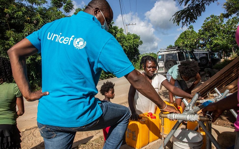 UNICEF-Mitarbeiter stellt sauberes Wasser aus einer Pumpe bereit.