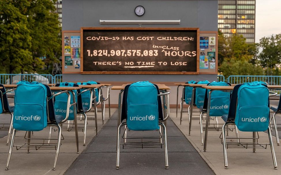Installation von UNICEF: Leeres Klassenzimmer und Uhr mit verpassten Unterrichtsstunden.