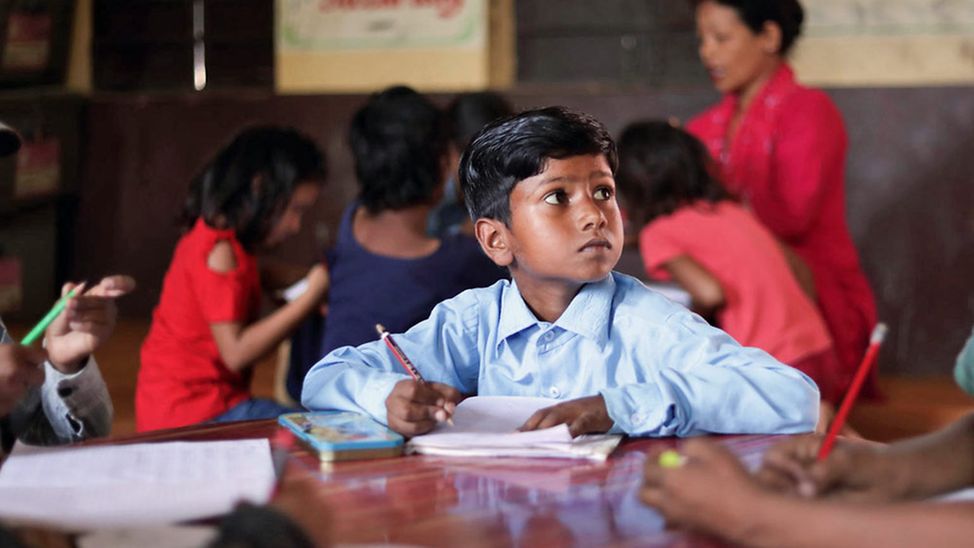 Bargeldhilfe (cash transfer) in Nepal ermöglicht Bildung: Ein Junge schreibt etwas in sein Schulheft. 