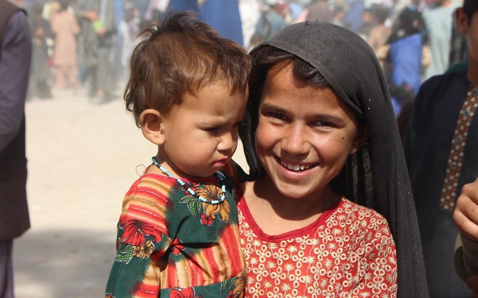 Afghanistan: Arifa hält ihre Schwester Safa auf dem Arm. beide sind Binnenvertriebene in Afghanistan.