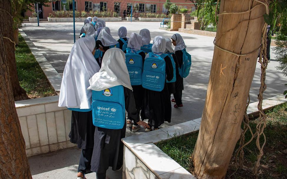 Afghanistan: Mädchen gehen mit UNICEF-Rucksäcken zur Schule