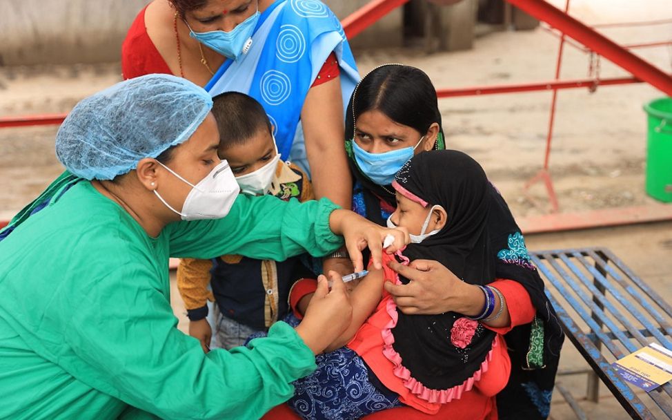 In Nepal wird ein Mädchen gegen Masern geimpft.
