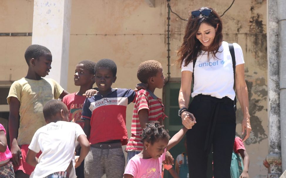 Tessa Page, Vorstandsvorsitzende United Internet for UNICEF, hält die Hand eines Mädchens in Mosambik..
