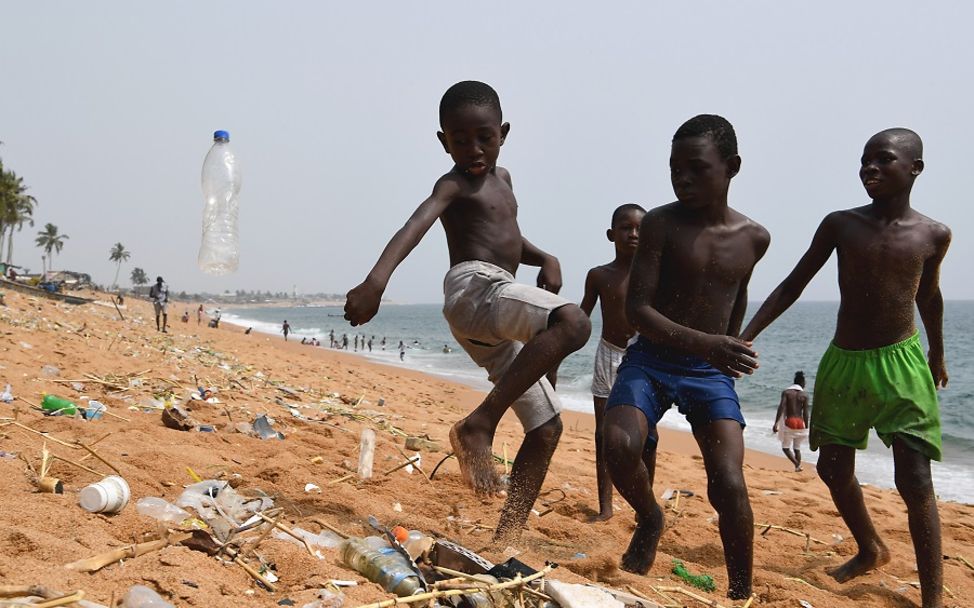 Elfenbeinküste: Kinder spielen mit Plastikmüll am Strand