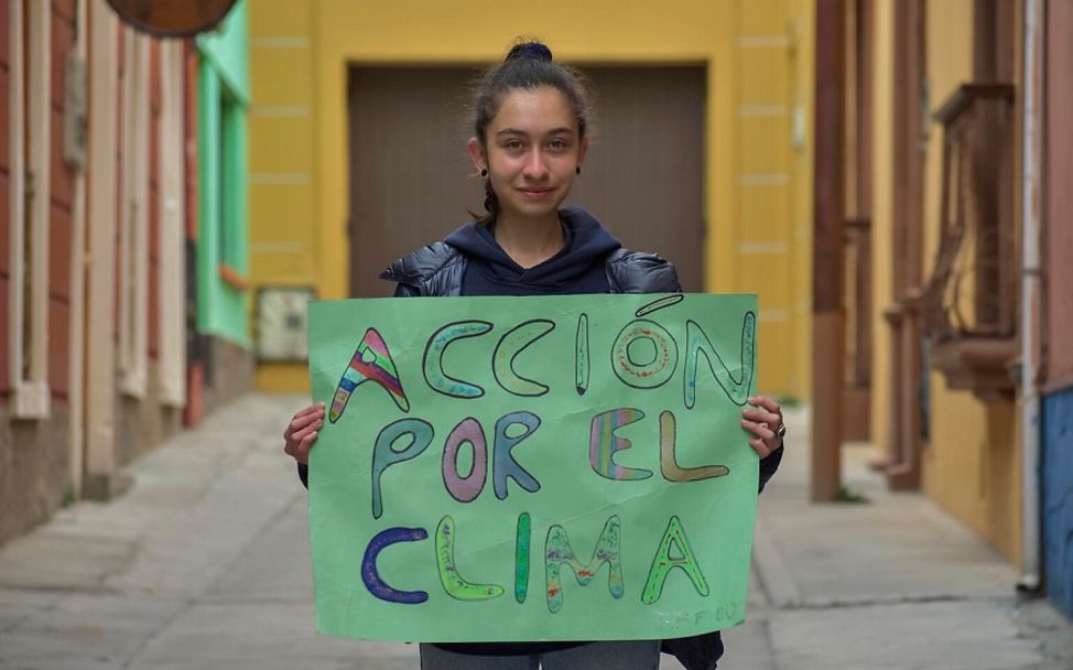 Bolivien: Klimaschutzaktivistin hält Schild hoch