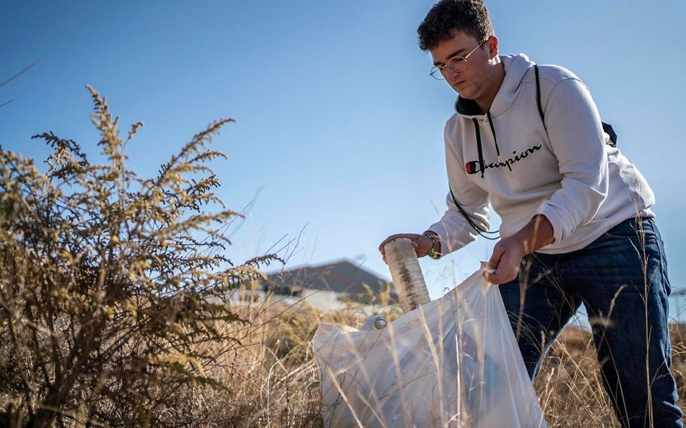 Spanien: Junge sammelt Müll in Natur