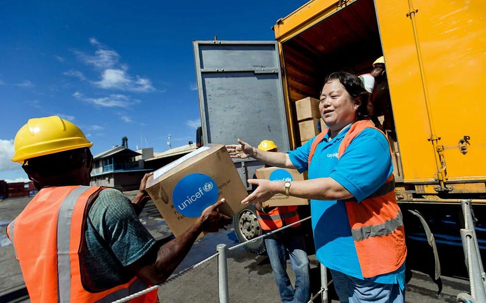 Naturkatastrophen spenden: UNICEF-Mitarbeiter*innen lagern Hilfsgüter in gefährdeten Regionen. 