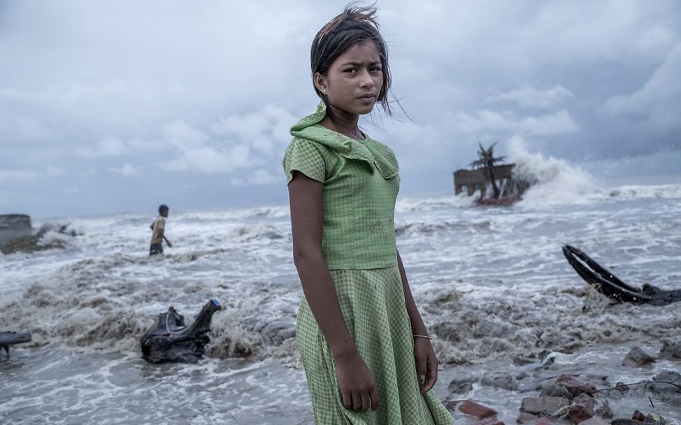Die zwölfjährige Pallavi steht vor dem Wasser, das ihr Zuhause weggeschwemmt hat.