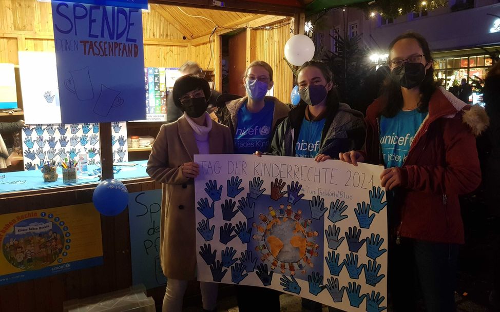 Frau Jansen und drei aus unserer Gruppe mit dem Plakat mit den blauen Händen