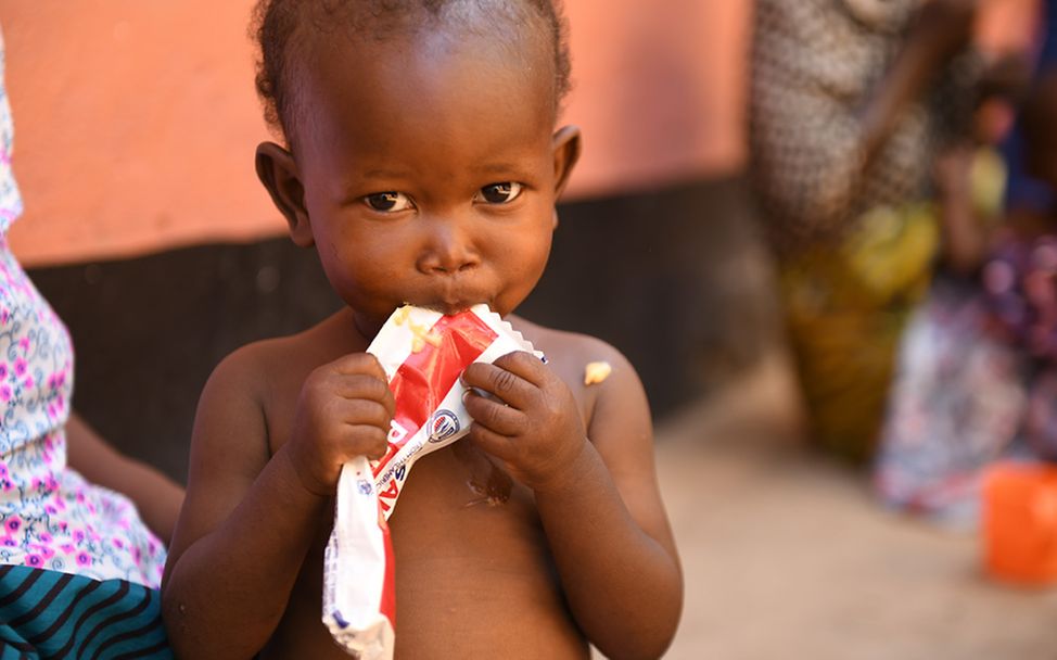 Malawi: Ein Kind isst Erdnusspaste